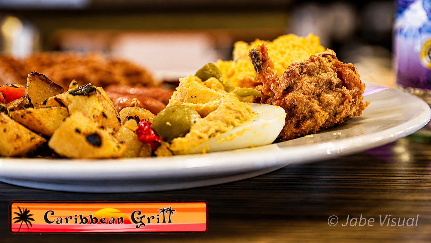 Brunch plate with jerk chicken, potatoes, deviled eggs and sausages
