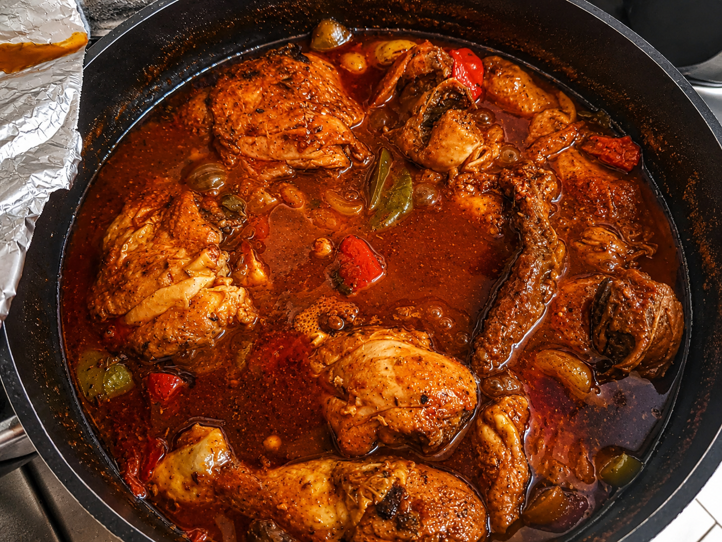 Traditional brown stew chicken in a pot