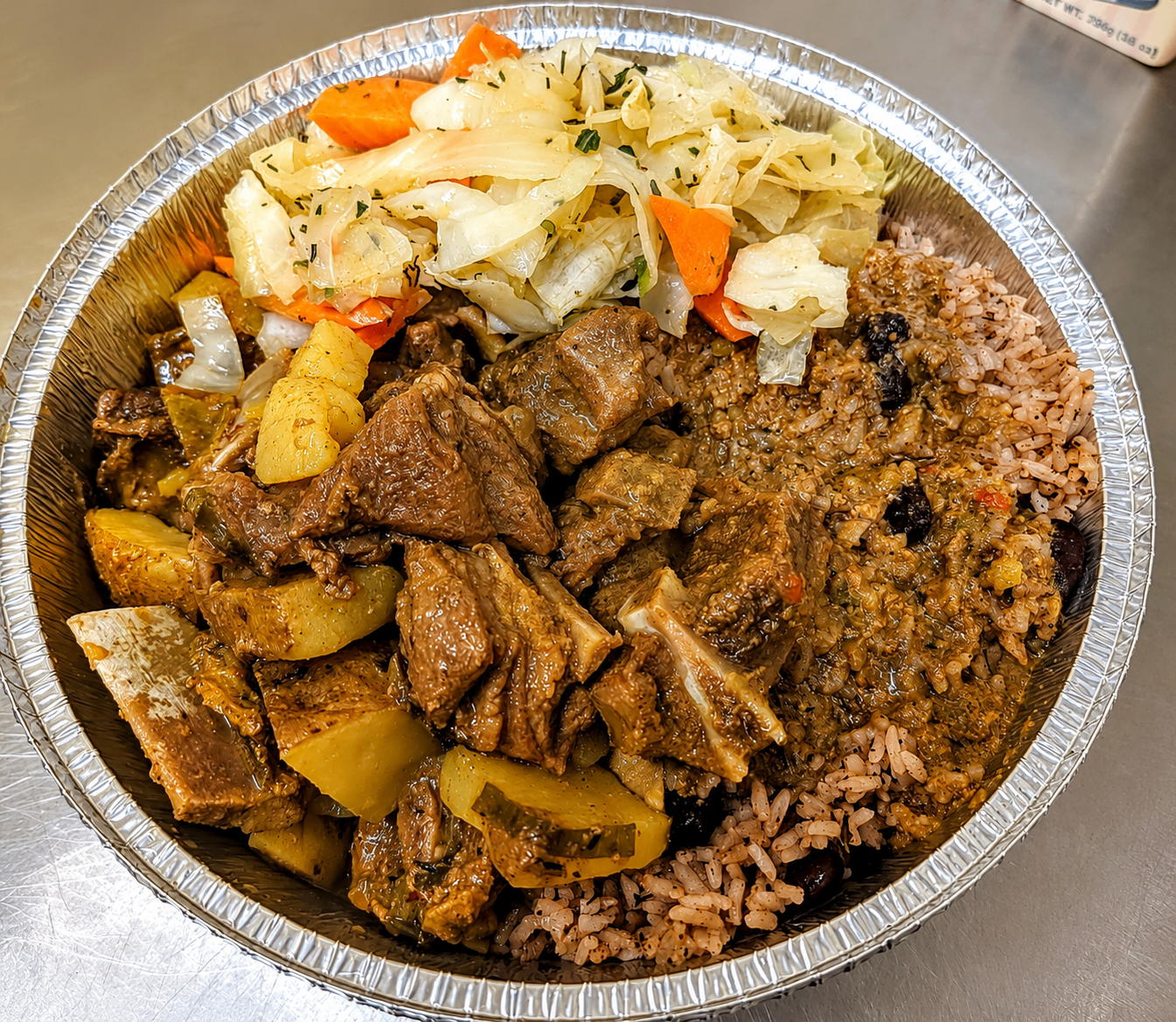 Curry goat with rice and peas and cabbage